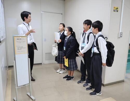 職員の説明を聞く生徒の画像