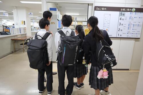 部屋の中の様子を見る生徒の画像