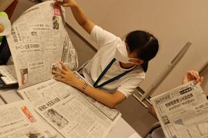 新聞記事を確認する生徒の画像