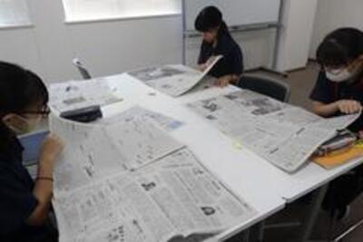 新聞記事の確認の様子の画像