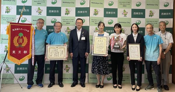 左から西東京市バドミントン協会理事長、西東京市バドミントン協会会長、市長、監督、選手、選手、西東京市バドミントン協会副館長、    西東京市体育協会事務局長