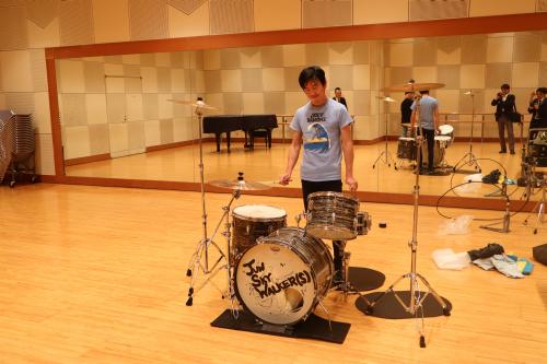 立ちながらスネアとフロアタムを叩いている小林さん